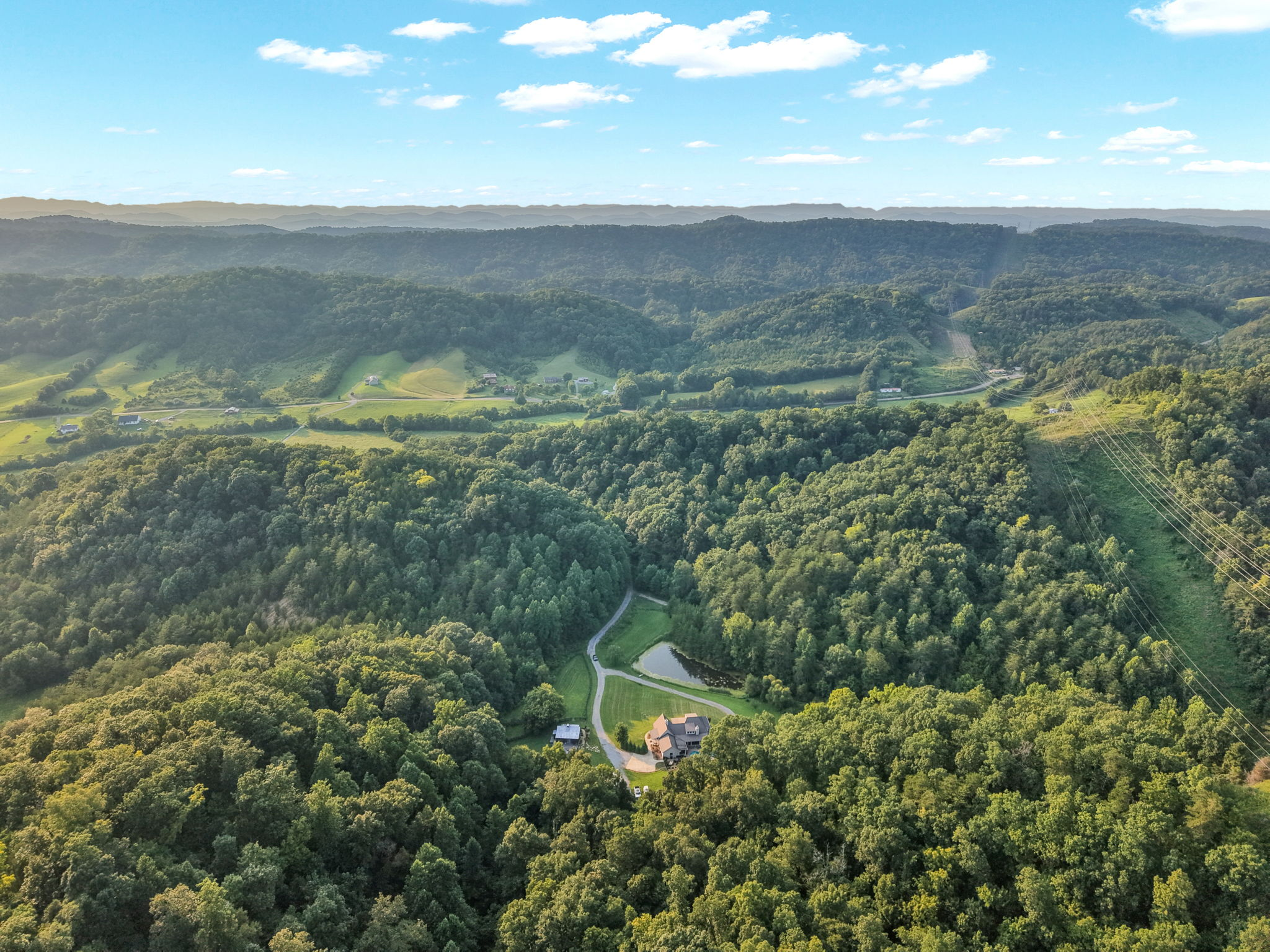 Wide aerial view across the estate toward the layered East Tennessee mountains